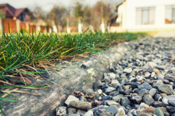 Decorative pea gravel placed next to a patch of grass